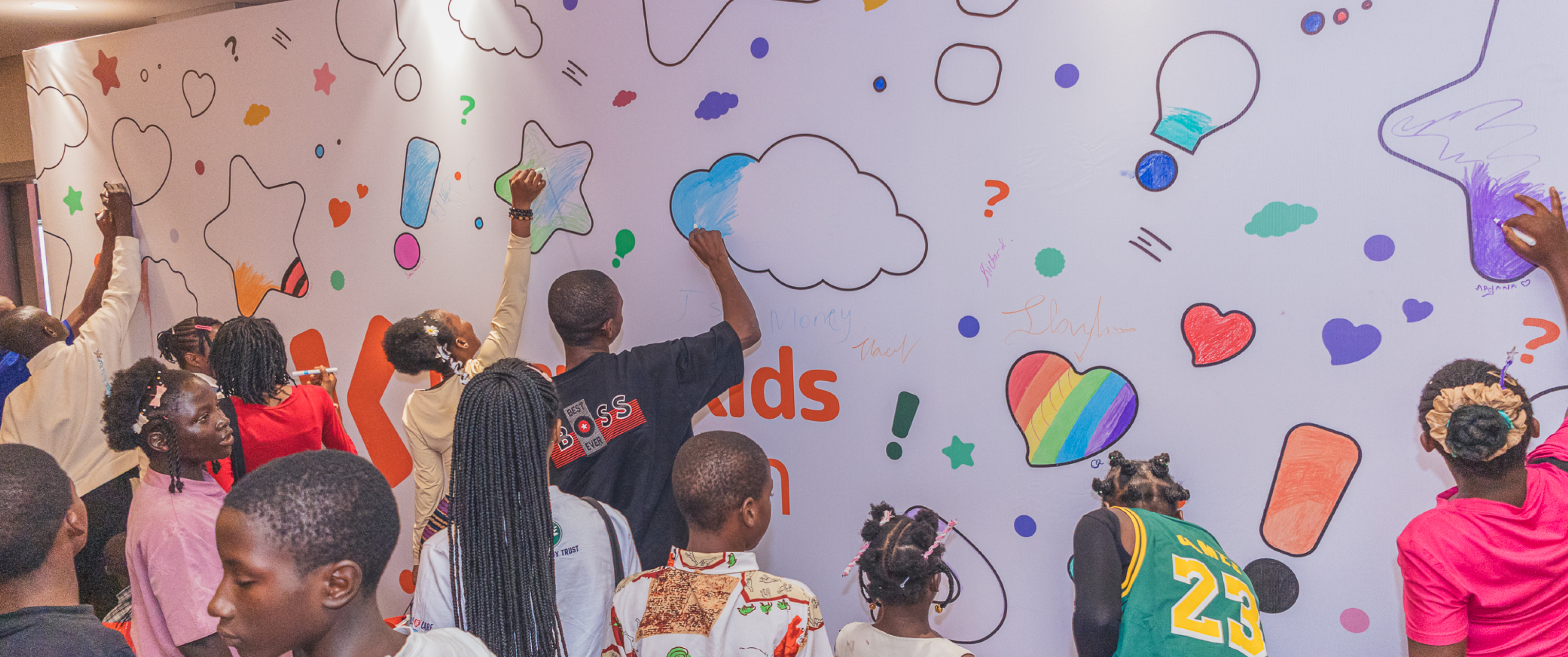 Children drawing on a wall at a Karanta Kids event